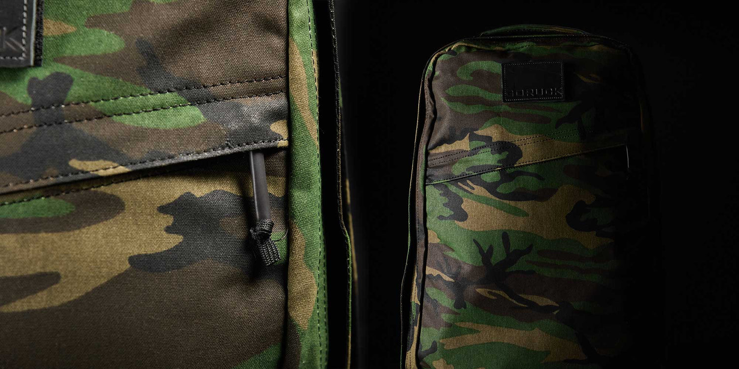 Close-up of two camouflage patterned bags against a dark background.