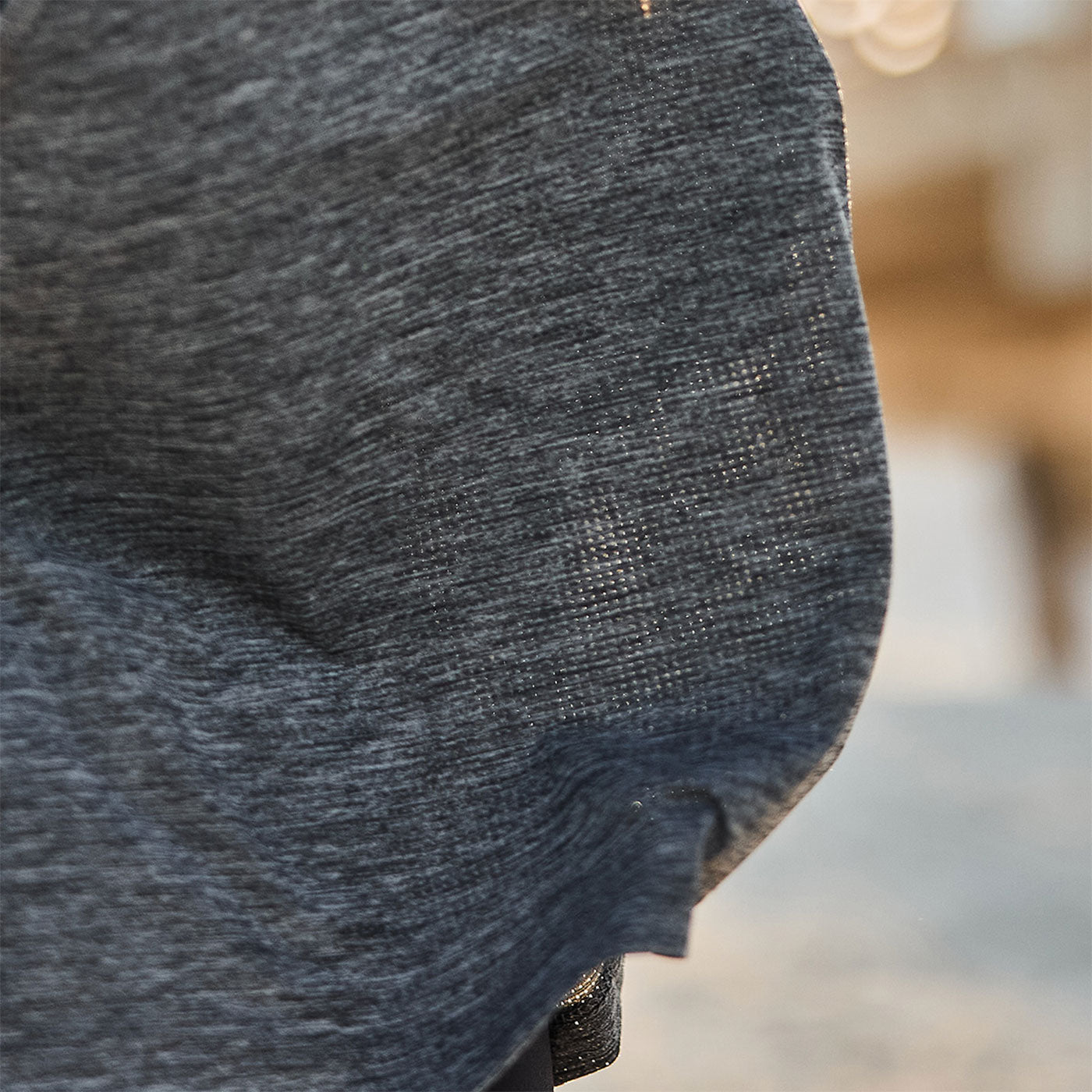 Close-up of a gray textured fabric with soft folds and blurred background.