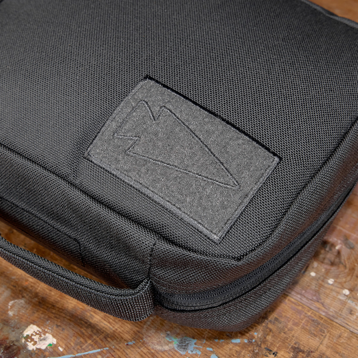 GORUCK padded field pocket in Armor Grey durable fabric on wooden surface