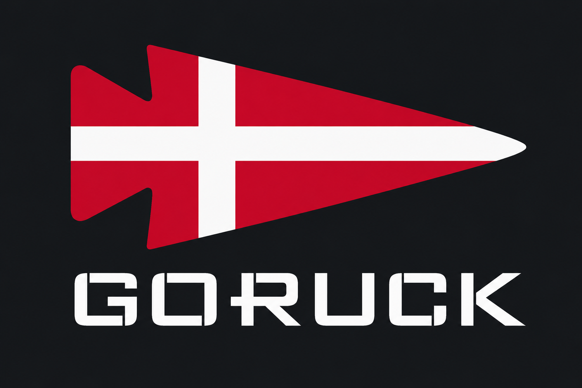 The Patch - Denmark by GORUCK features a red arrowhead with a white cross, resembling Denmark’s flag, above the brand name “GORUCK” on a black background.