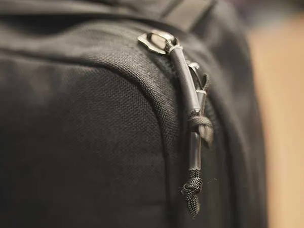 Close-up of a black bag’s zipper with a small lock securing the zipper pulls together.