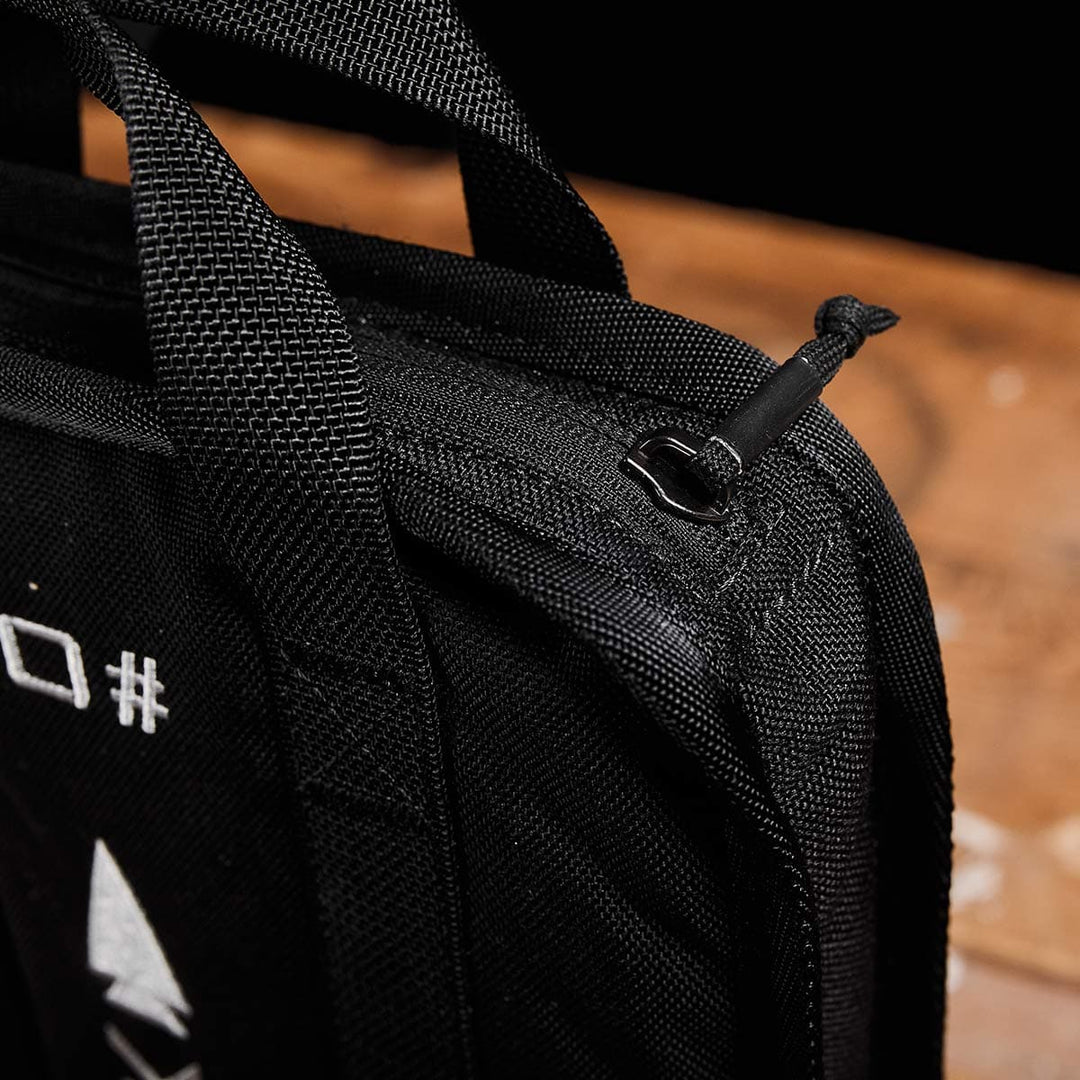 Close-up of a black fabric bag featuring a zipper and sturdy handles, designed by GORUCK for rucking. It’s perfect for carrying your portable Sand Ruck Plates, all placed neatly on a wooden surface.