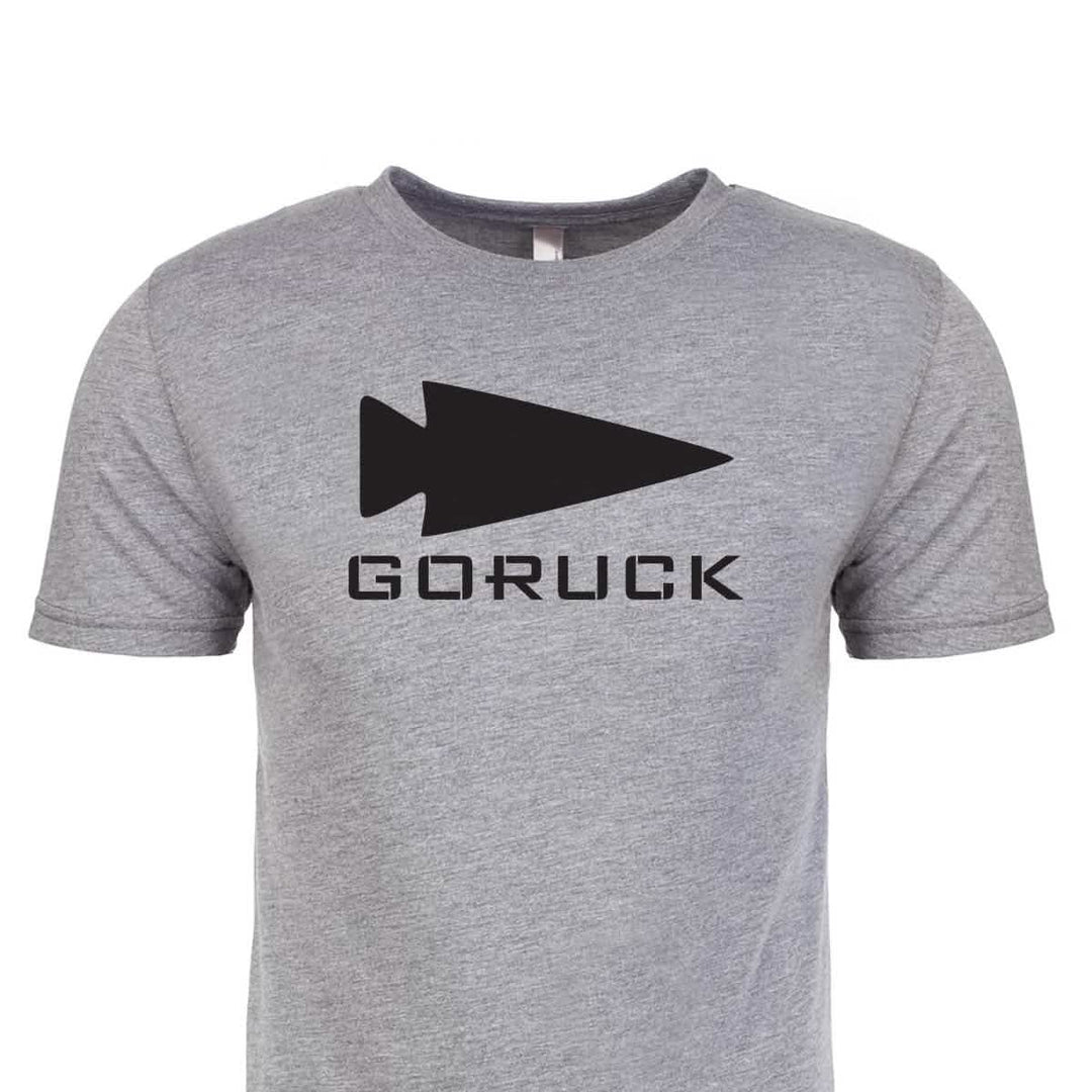 The Three Rules Tee - Tri-Blend by vendor-unknown is a gray premium t-shirt featuring a bold black arrowhead logo and "GORUCK" beneath—perfect for both everyday adventures and memorable photos.