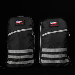 Two black GORUCK rucking backpacks with reflective stripes and American flag patches