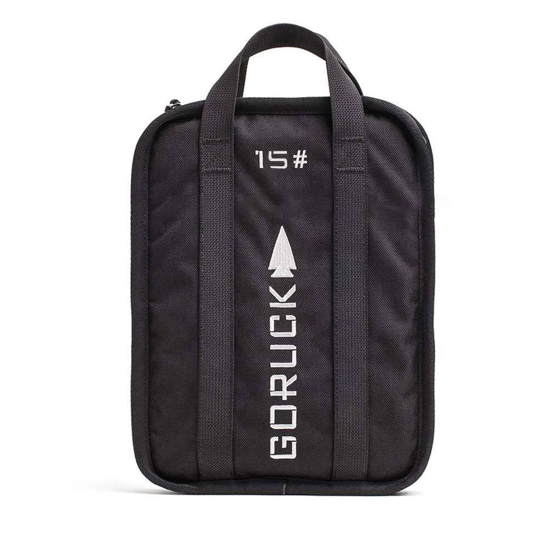 GORUCK Sand Ruck Plate bag in black with white text and arrow design, equipped with dual handles and a compact, rectangular shape ideal for carrying a portable Ruck Plate during rucking adventures.