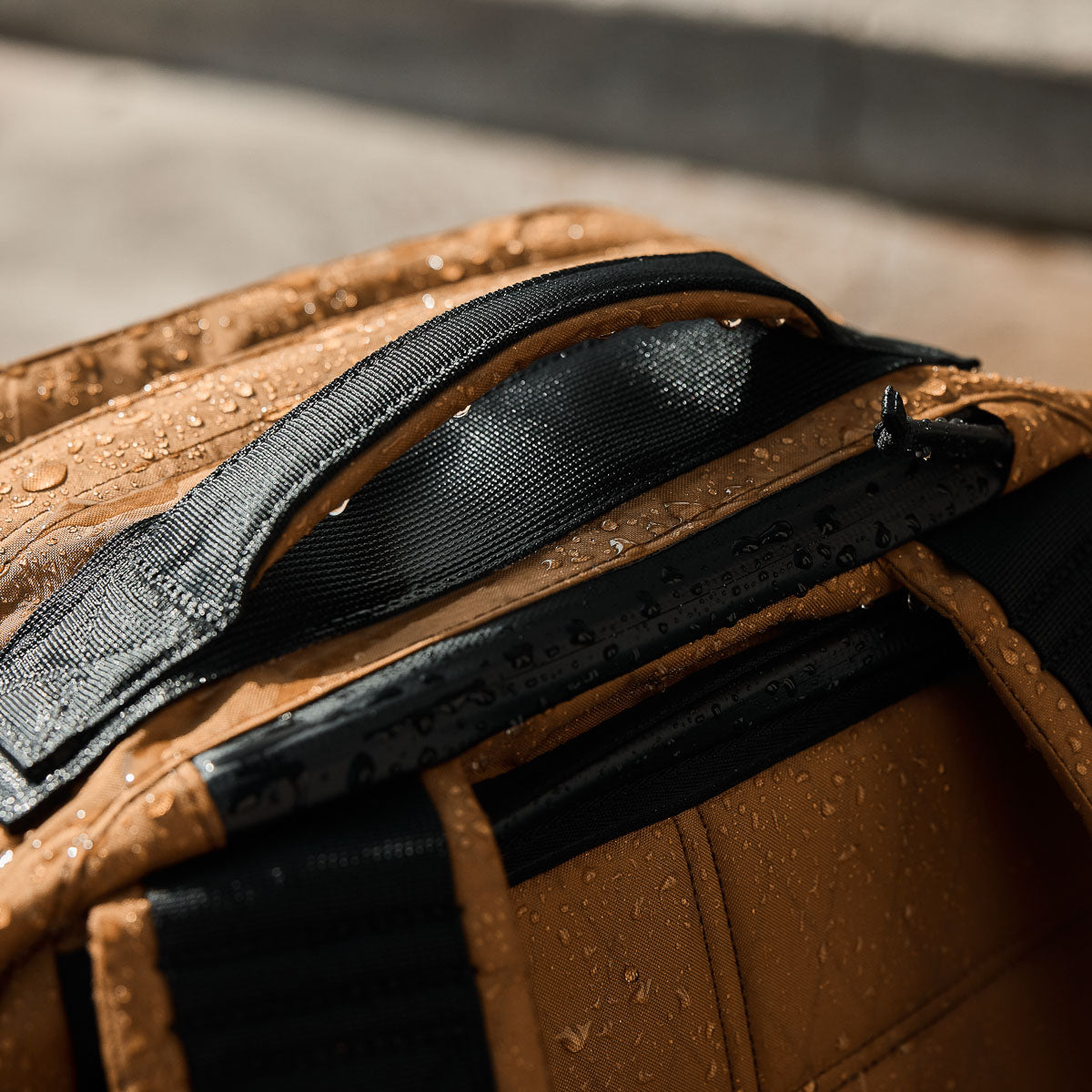 GORUCK weather-resistant rucksack handle with water droplets, rugged outdoor gear close-up
