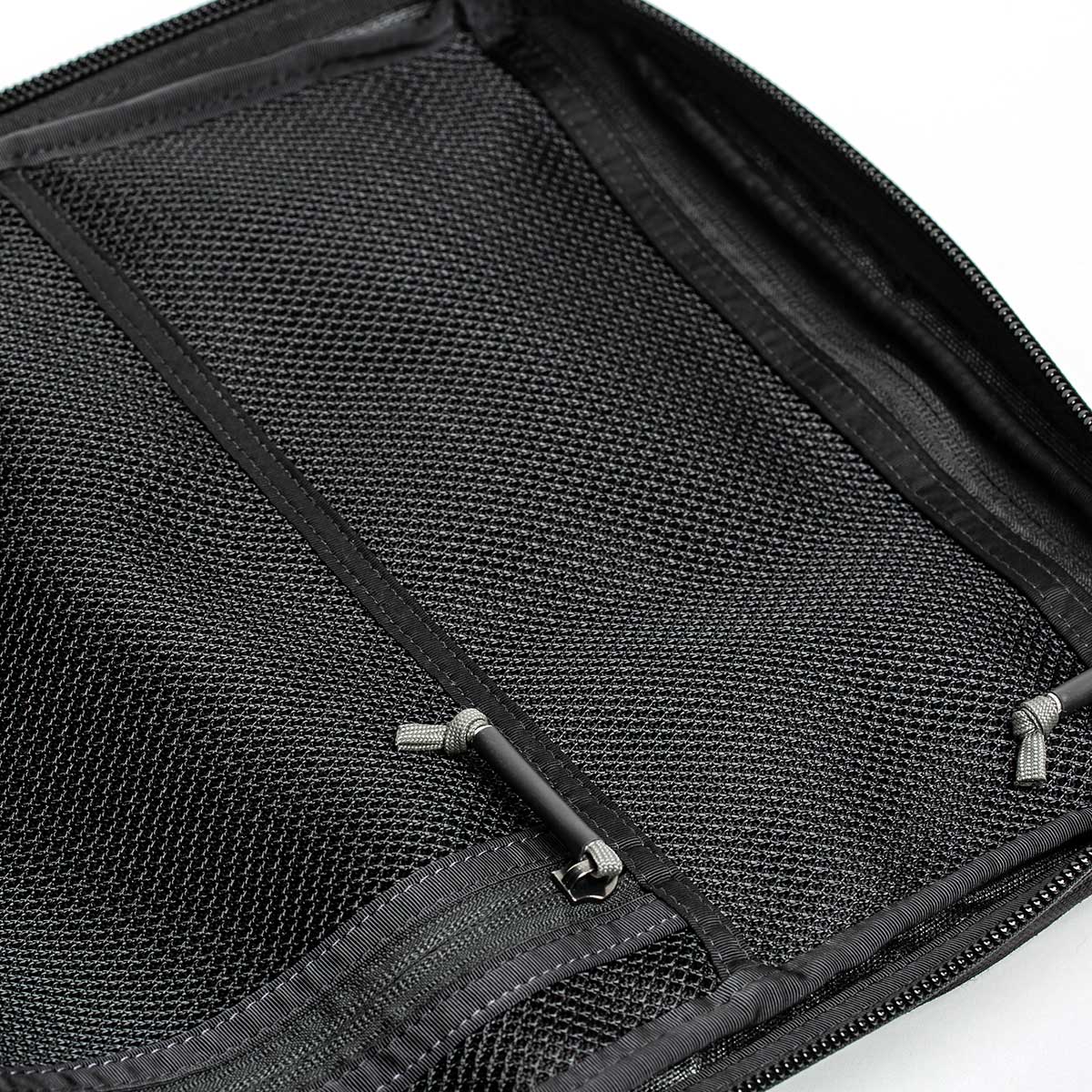 Close-up of an open black mesh organizer, featuring zippers and storage sections, engineered with the precision of GORUCK's GR2 backpacks.