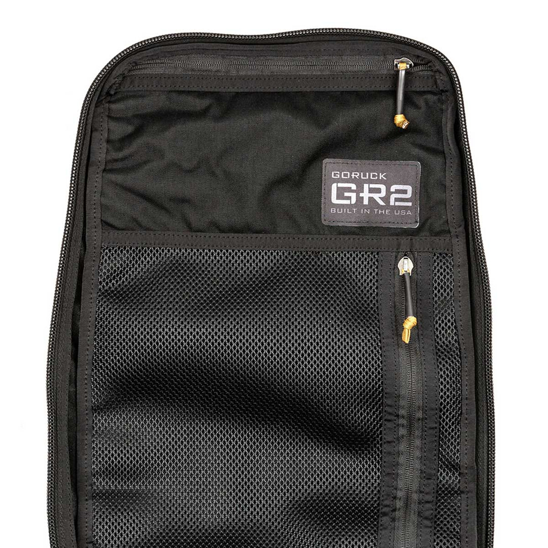The interior of the black GR2 from GORUCK features mesh pockets and zippers, ideal for keeping organized and securing your gear. Additionally, it's carry-on compliant and comes with the Scars Lifetime Guarantee to ensure peace of mind on all your adventures.