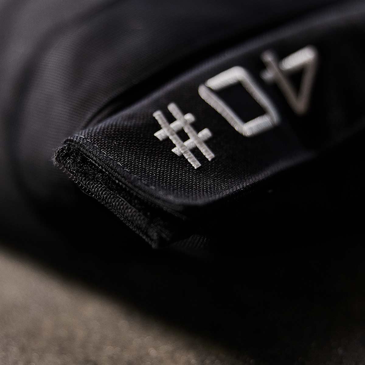 A close-up shows a black tag with white 