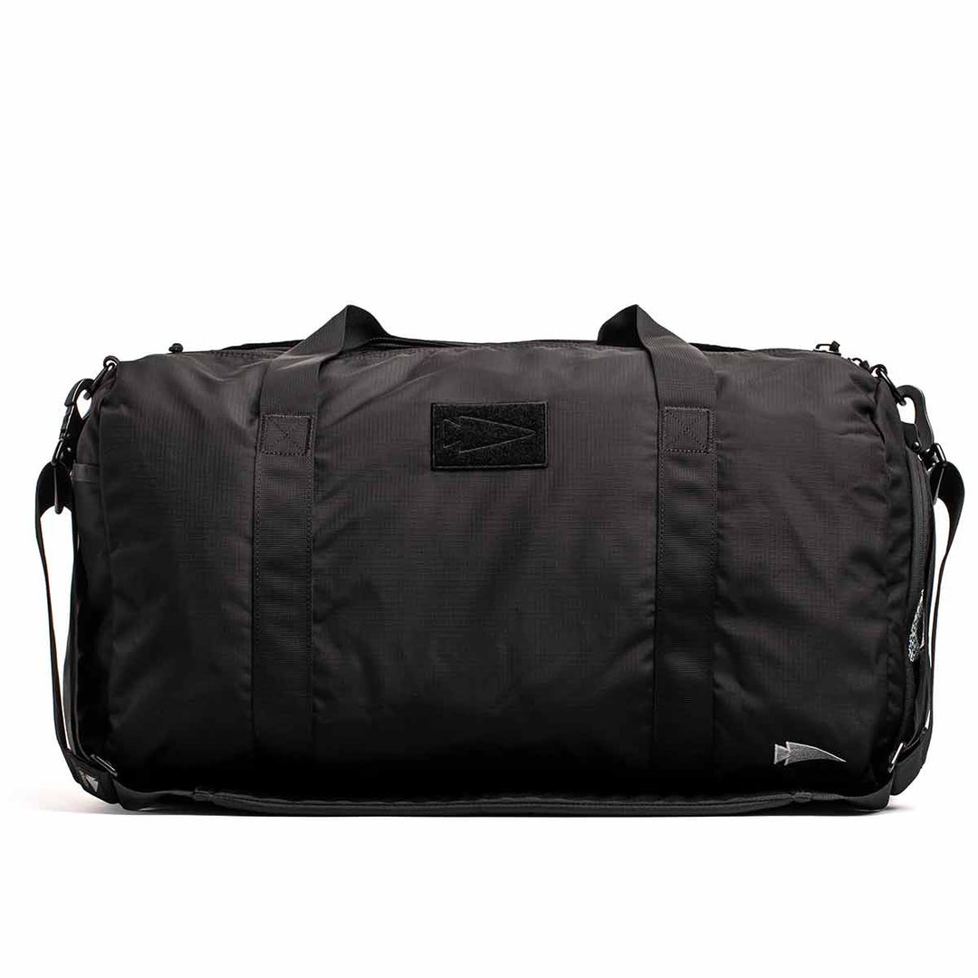 The GORUCK Gym Bag - Ripstop ROBIC® is a black, durable gym bag made from ripstop nylon. It features dual handles and a shoulder strap for effortless carrying and includes a shoe compartment, set against an eye-catching white background.