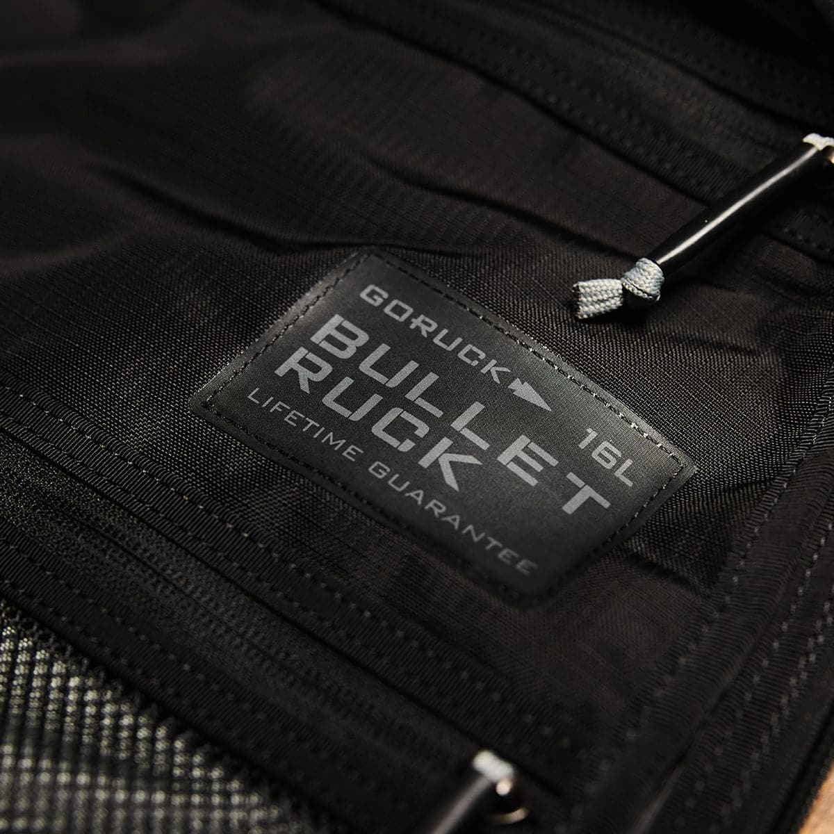Close-up of a label on the GORUCK Bullet Ruck Double Compartment - Ripstop Nylon travel backpack displays 
