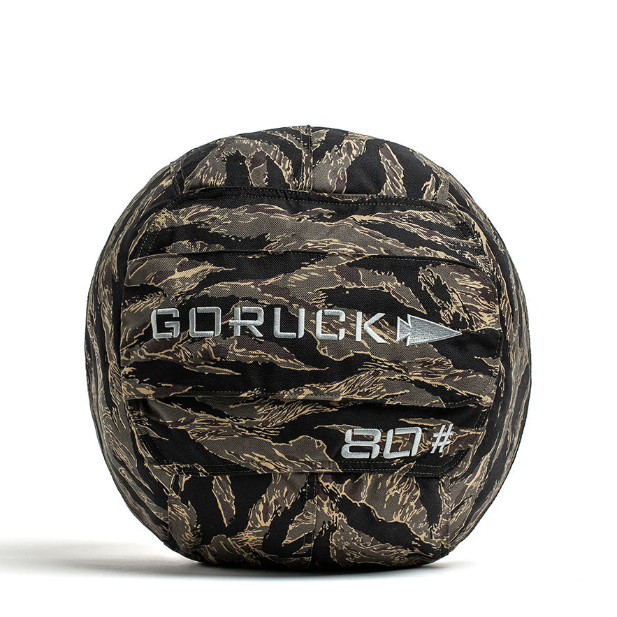 A black Sand Medicine Ball by GORUCK, featuring a handle, is perfect for boosting core stability at home. The ball is marked with the brand name GORUCK and the number 80# in white text, making it a versatile piece of equipment for your home gym collection.