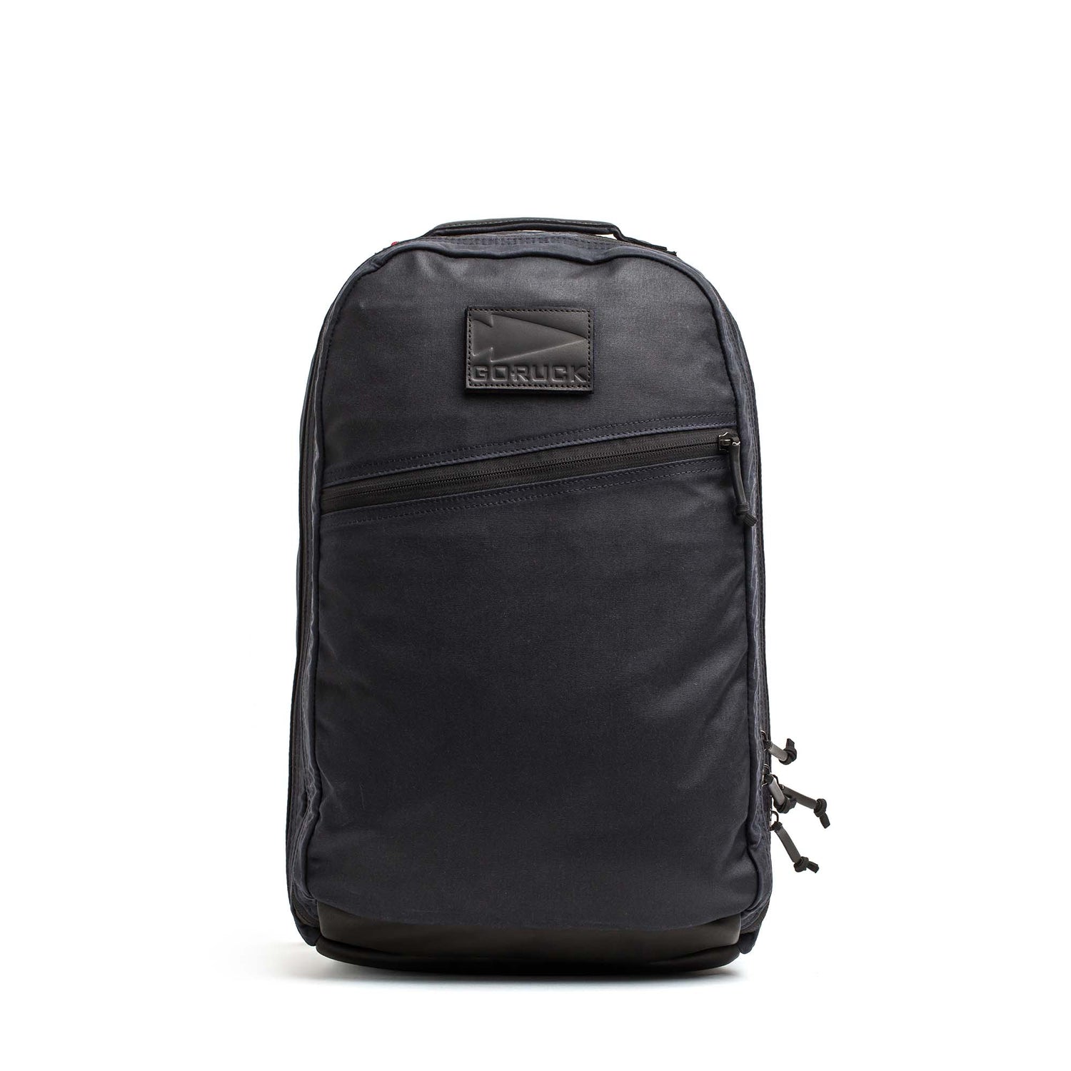 The GORUCK Bullet Ruck - Heritage Waxed Canvas - 18L, crafted from black waxed canvas and featuring a front zipper pocket with a signature GORUCK logo patch, is shown against a white background—making it the ideal daypack for your daily adventures and travel.