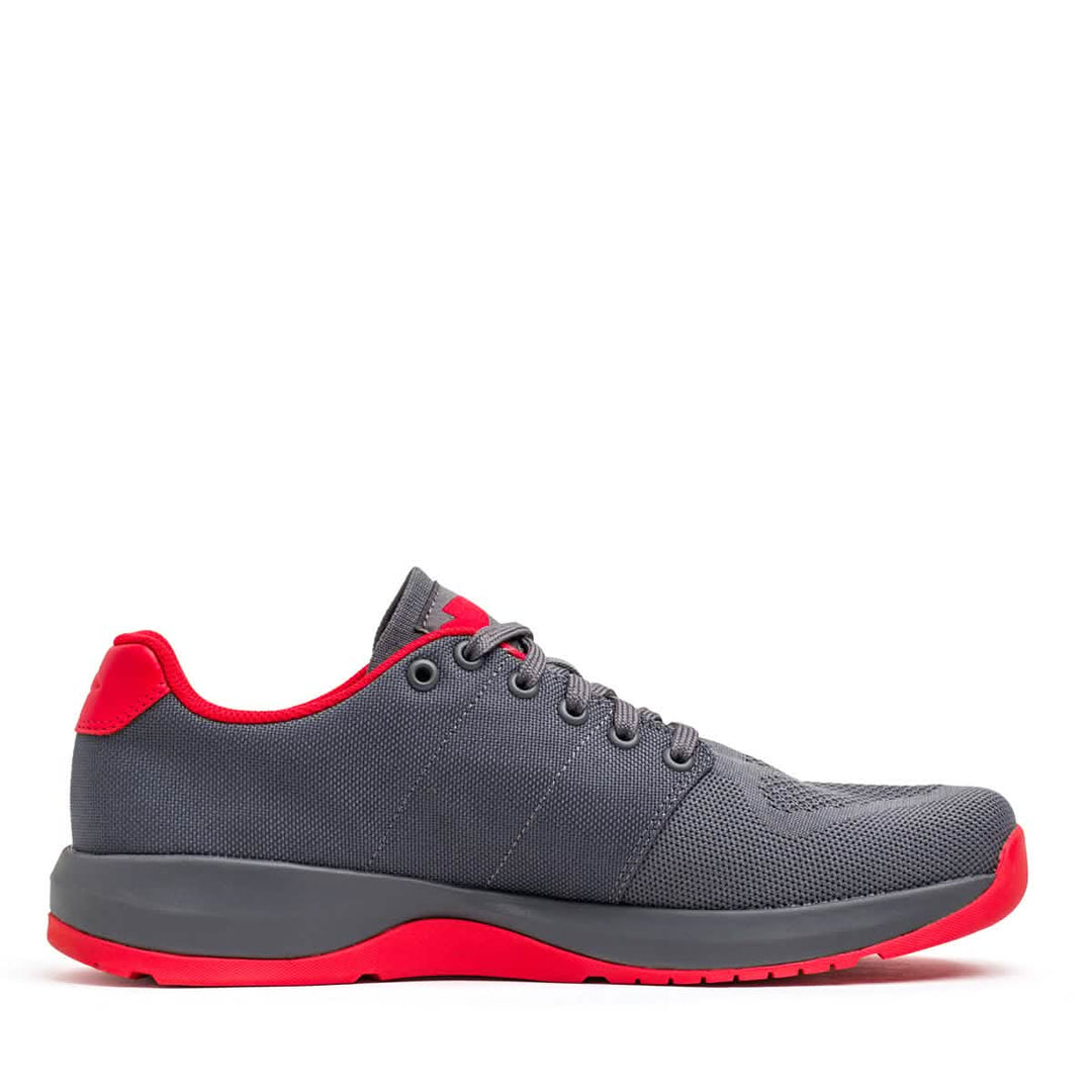 The GORUCK Ballistic Trainers in Wolf Grey + High Risk Red feature durable CORDURA® Ballistic Nylon with bold red accents and a reflective spearhead—functional fitness sneakers shown in a side profile view.