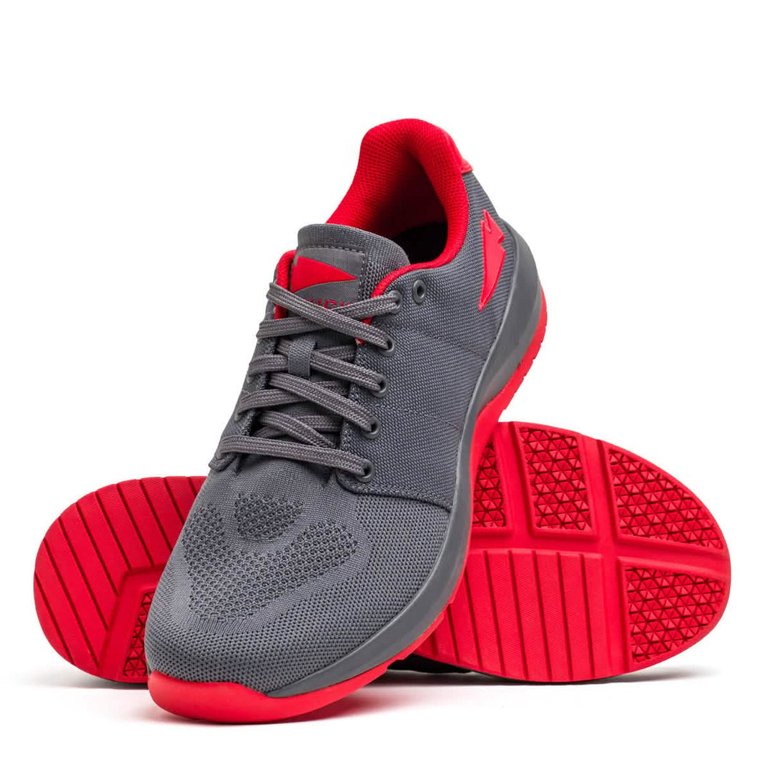 The GORUCK Ballistic Trainers in Wolf Grey + High Risk Red W / Red Reflective Spearhead feature durable CORDURA® Ballistic Nylon, red soles and lining, and are shown from the side and bottom as ideal functional fitness shoes.