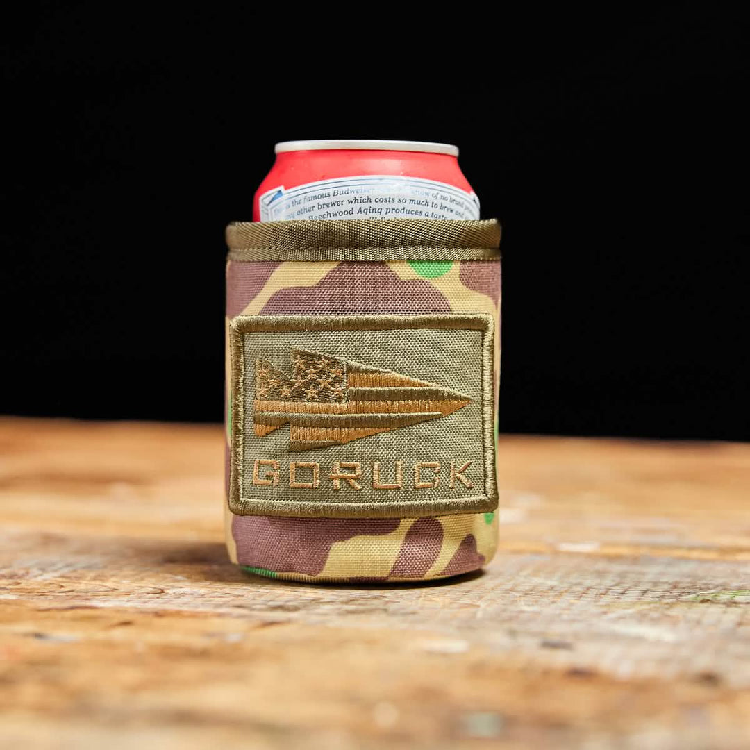 The GORUCK Ballistic Beer Jacket, made of rugged 1000D CORDURA with a GORUCK patch, keeps your cold beer or soda can chilled on any surface.