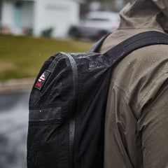 GORUCK black packable backpack in rain on person's shoulder, rugged outdoor rucking gear