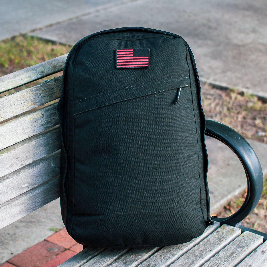 GORUCK black rucksack backpack with flag patch on bench outdoors