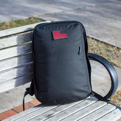 GORUCK black rucking backpack with red patch on park bench outdoors