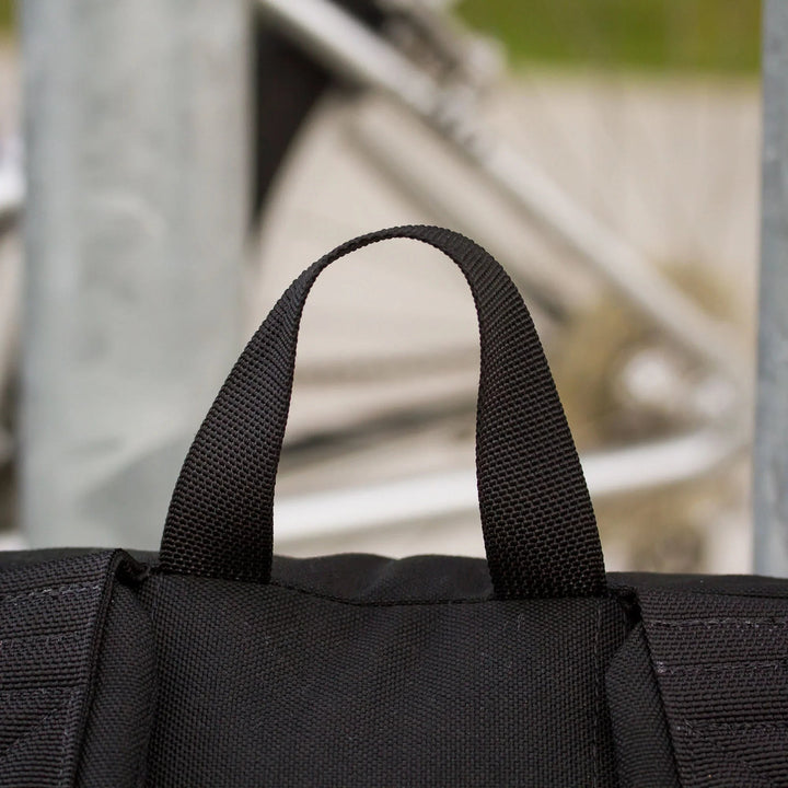 Close-up of GORUCK black rucksack handle with outdoor urban background