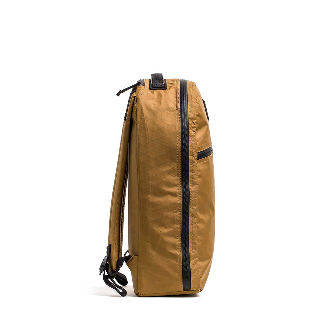 Side view of the GORUCK Bullet X-PAC, a brown weatherproof backpack with black zippers and straps against a white background—ideal as a durable daypack.