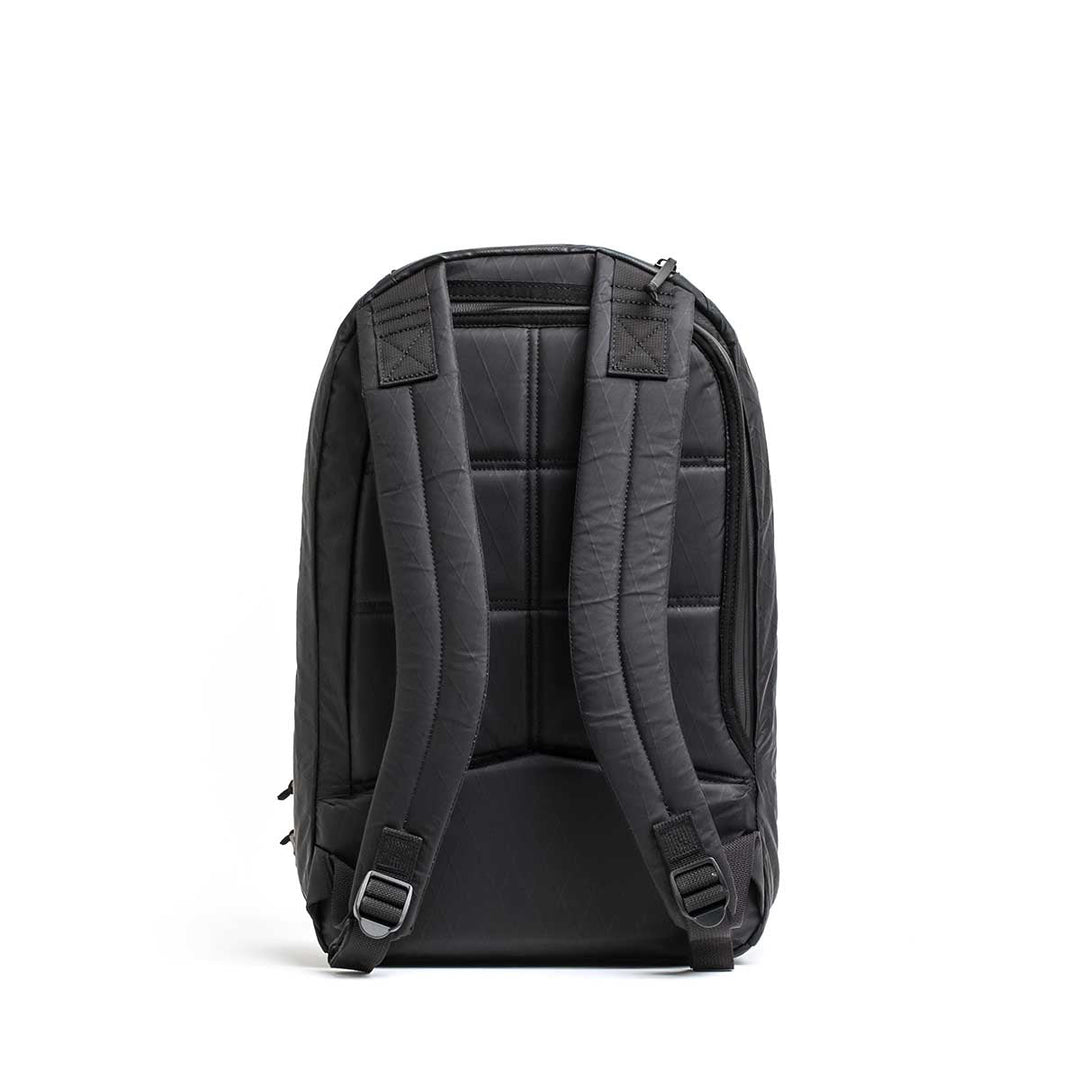 The Double Compartment Bullet Ruck - XPAC in black is shown from the back, highlighting padded shoulder straps, a quilted back panel, and a bombproof laptop compartment for secure travel.