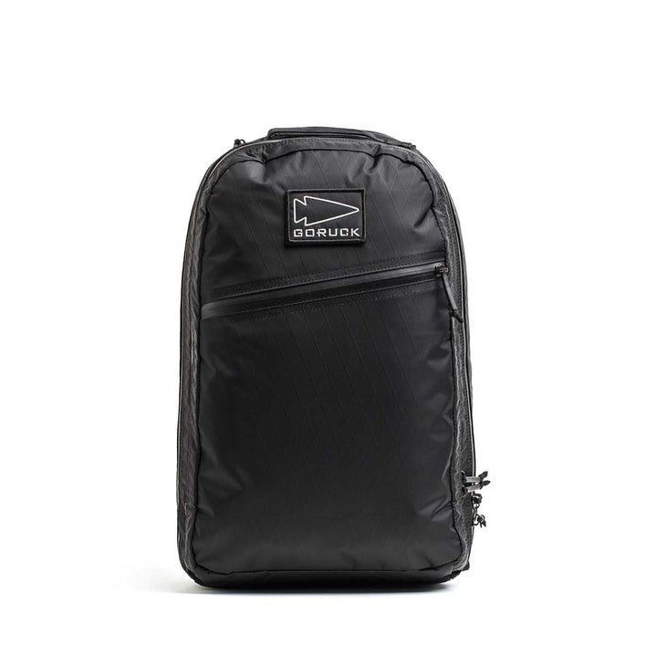 The Double Compartment Bullet Ruck - XPAC is a black GORUCK travel backpack featuring a diagonal zipper pocket, double compartment ruck design, and logo patch, shown on a plain white background.