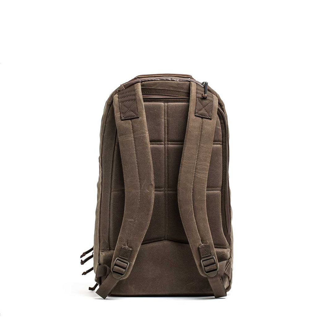 GORUCK Bullet Ruck - Heritage Waxed Canvas - 18L backpack features padded shoulder straps and back panel for comfort, made from durable waxed canvas—ideal for hands-free travel, shown from the rear on a white background.
