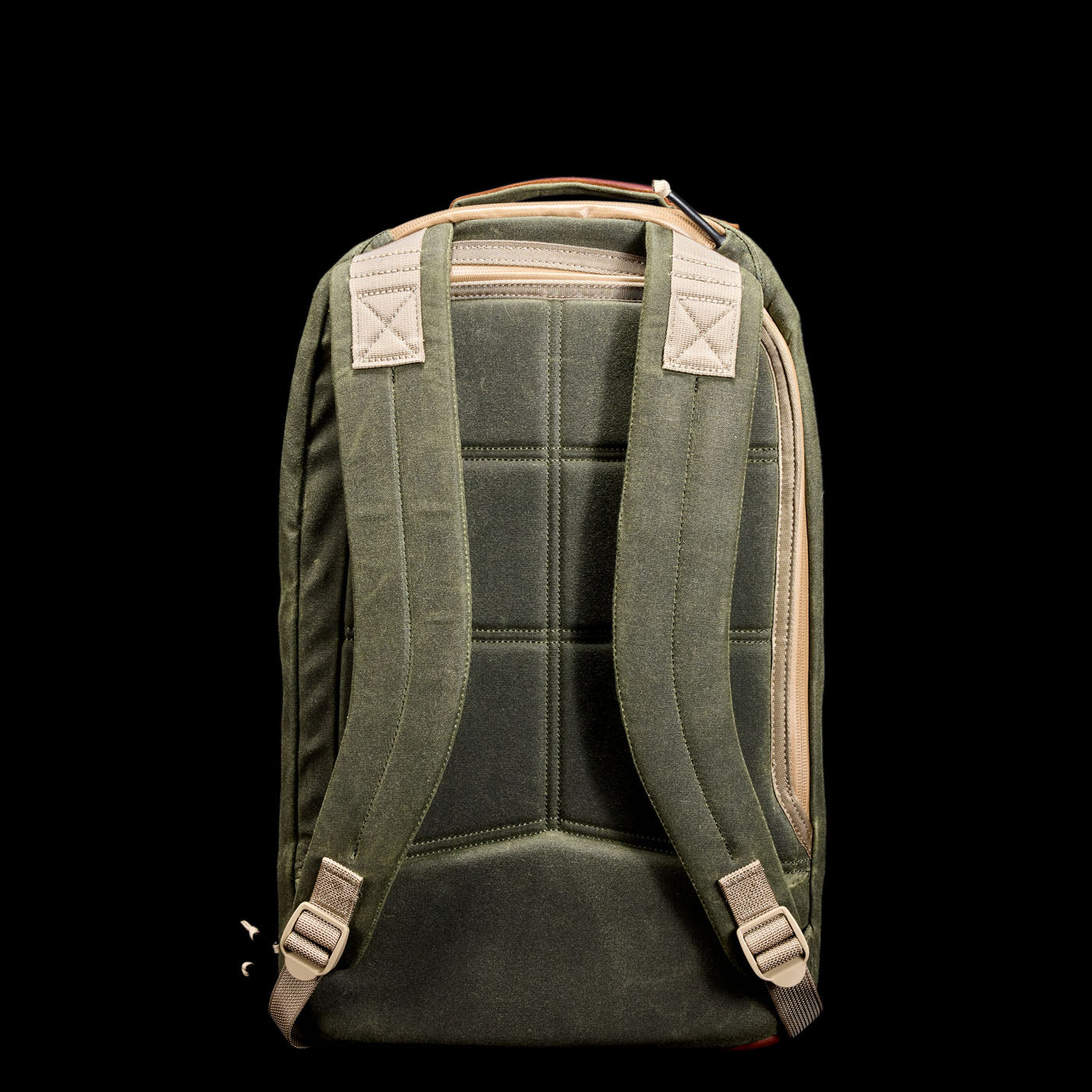 Green canvas backpack with beige straps shown from the back against a black background.
