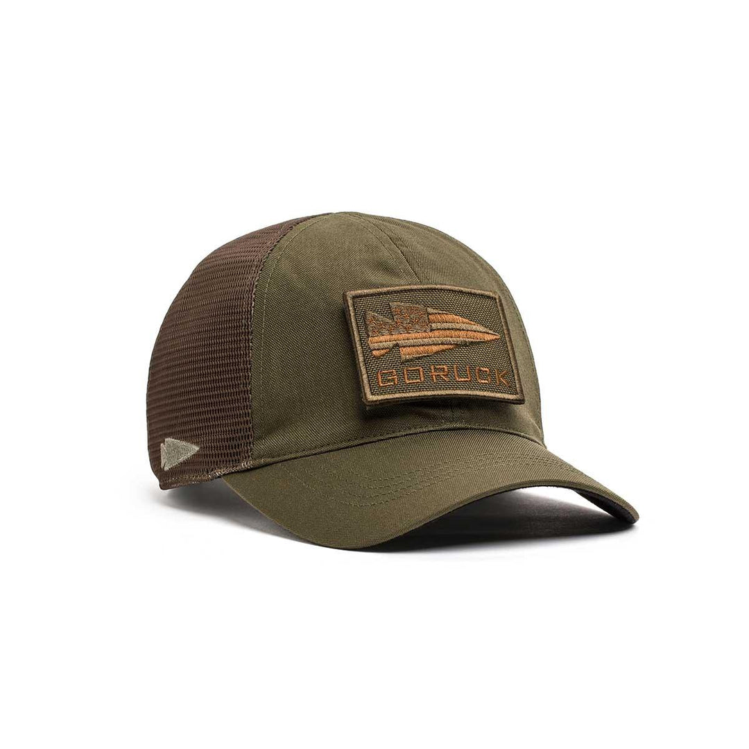 The GORUCK Cadre Hat - CORDURA® is an olive green and brown mesh baseball cap made from rugged 500D CORDURA®, with a rectangular GORUCK patch on the front and covered by the Scars Lifetime Guarantee.