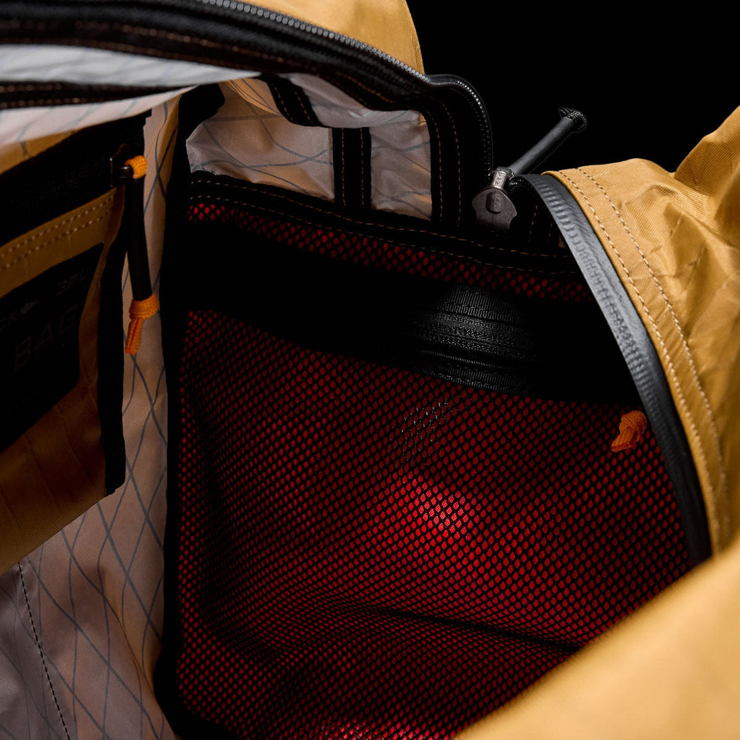 Close-up of the Kit Bag - X-PAC’s interior, showcasing a red mesh pocket and yellow fabric lining made from durable X-PAC VX21 material.