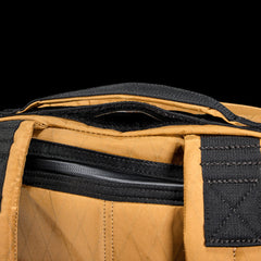Close-up of GORUCK coyote brown rucksack with black stitching and zipper detail