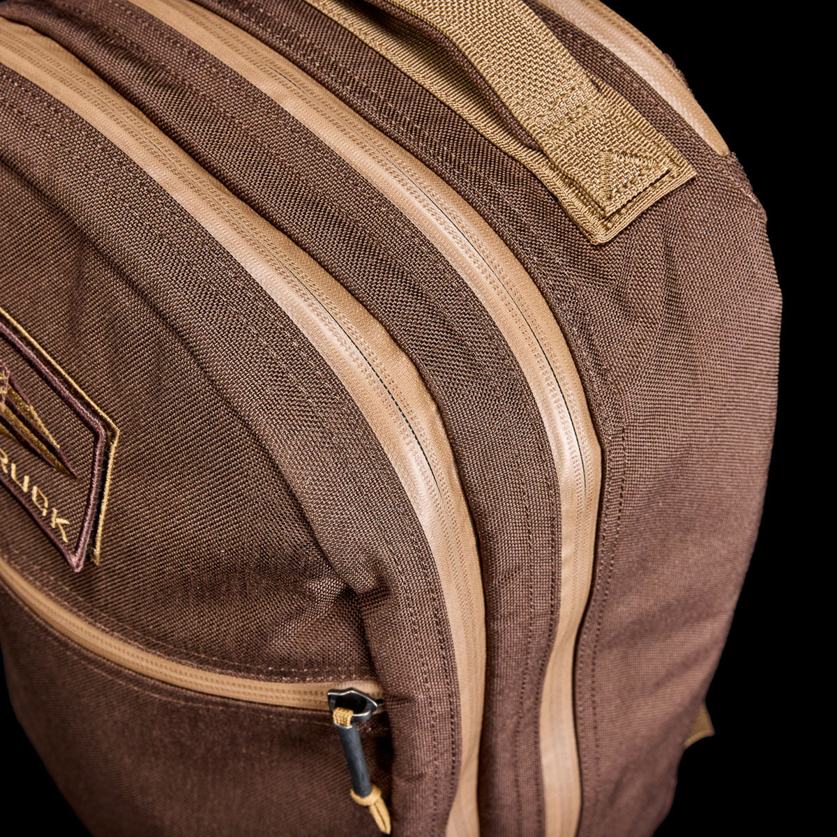 GORUCK brown Bullet Ruck backpack with durable fabric and dual tan zippers, close-up