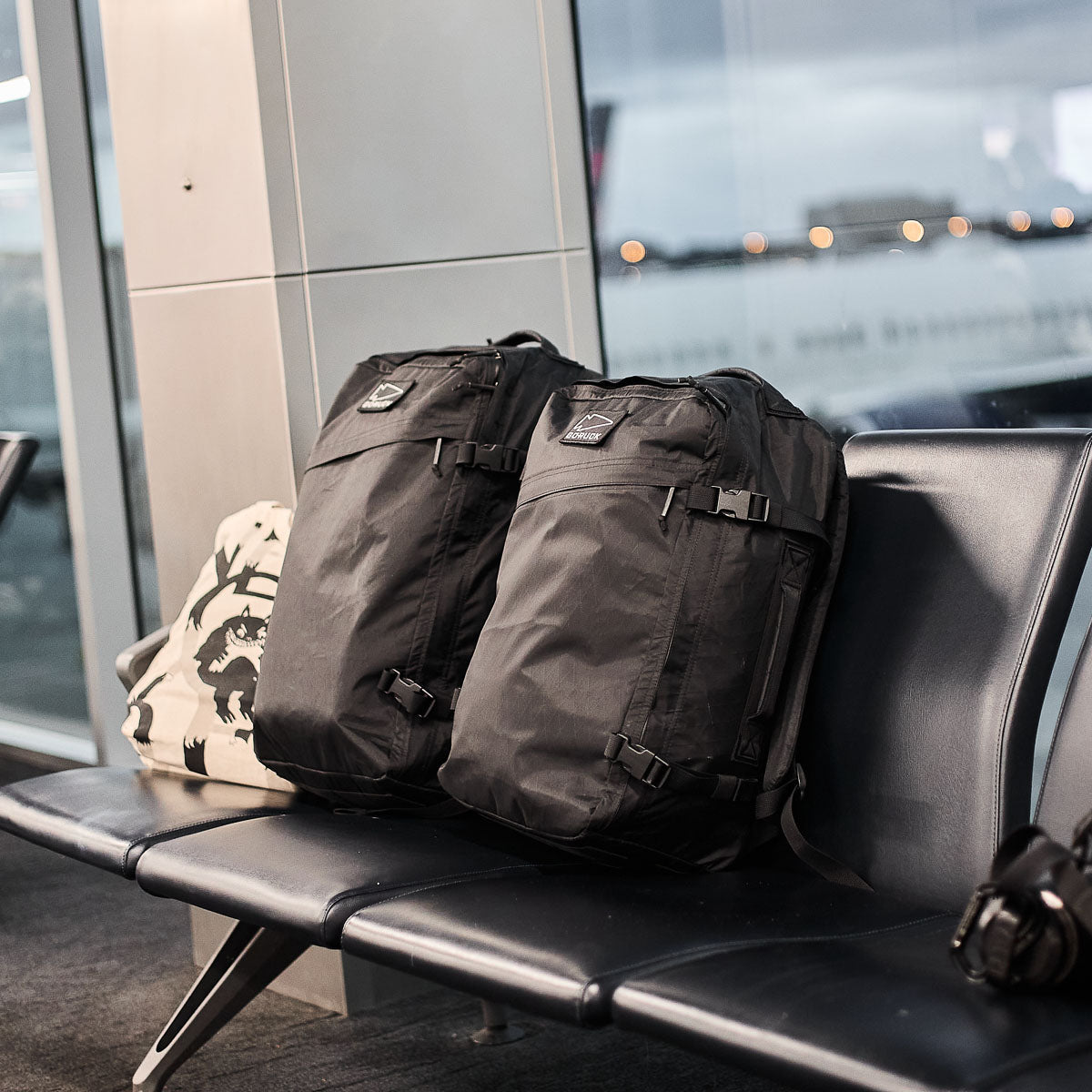GORUCK black rucksacks on airport bench, rugged travel backpacks ready for rucking adventure