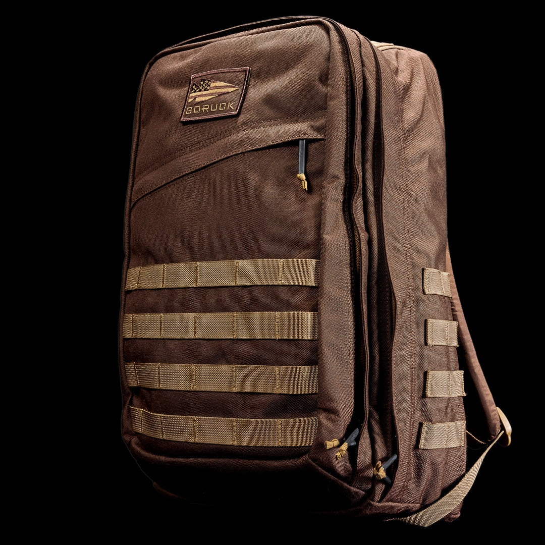 The GORUCK GR2 is a brown tactical travel backpack with beige straps and a GORUCK logo, designed after Special Forces rucksacks and shown against a black background.