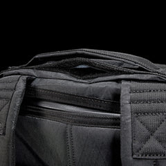 GORUCK black ruck backpack top handle and zipper detail against black background