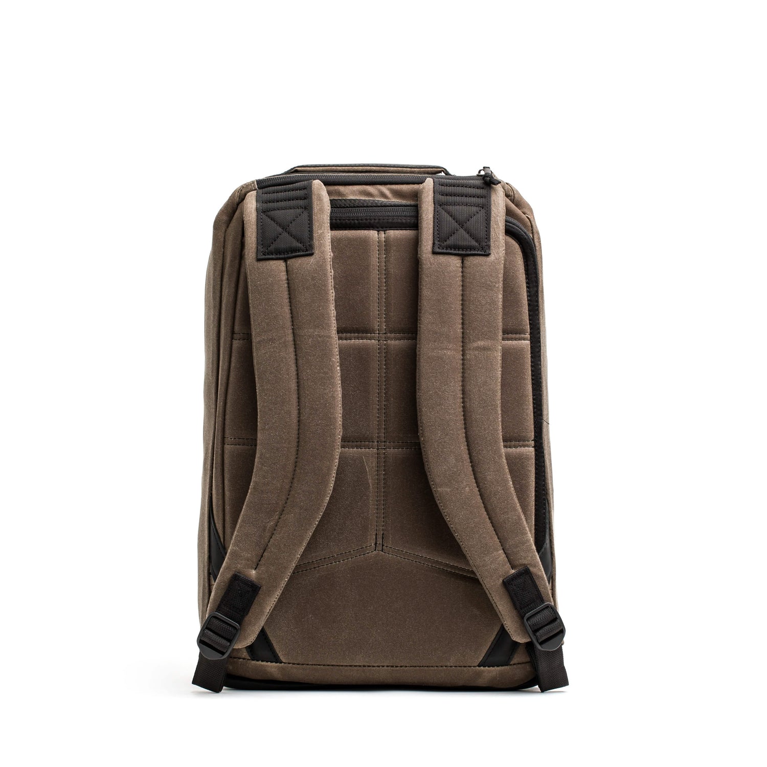 The back view of the GR1 USA - Heritage by GORUCK reveals a padded waxed canvas backpack in brown, featuring adjustable shoulder straps and subtle black accents.