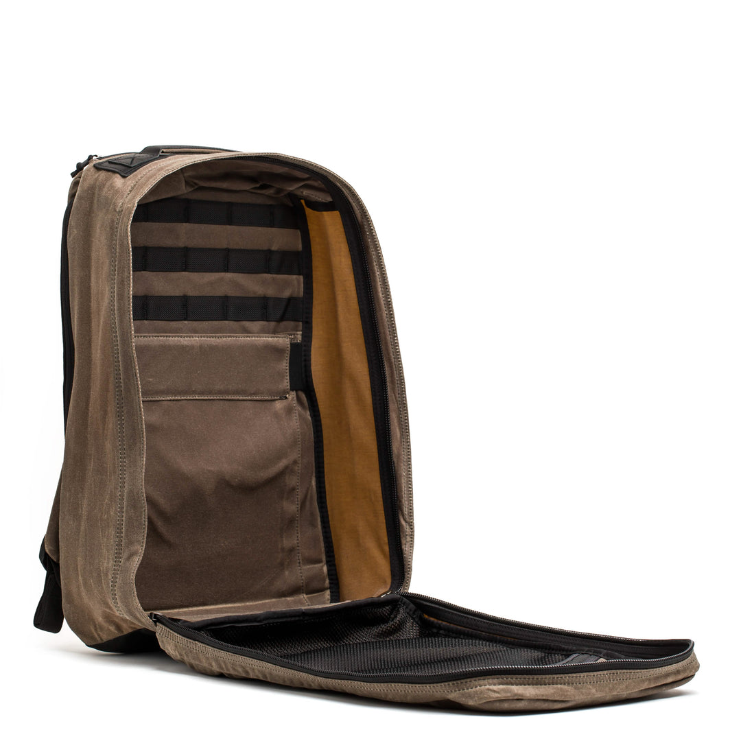 The GR1 USA - Heritage backpack by GORUCK, featuring an open design, multiple compartments, and a flat base made from retro canvas rucksack material, stands against a white background.