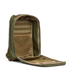 A GR1 USA - Heritage Rucksack by GORUCK, made from Waxed Duck Canvas in green, is shown open on a white background, highlighting its various compartments and pockets.