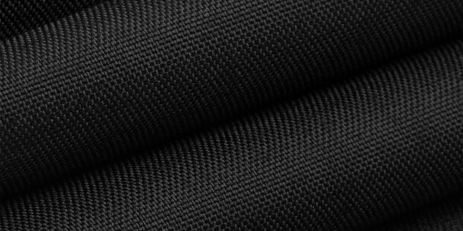 Close-up of folded black textured fabric with a fine, grid-like weave pattern.