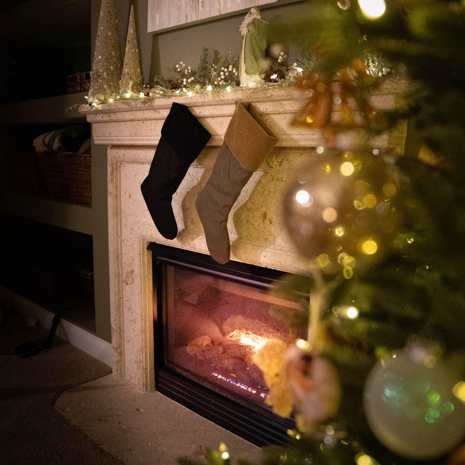 Cozy fireplace with GORUCK stockings hanging, holiday lights, and Christmas tree decor