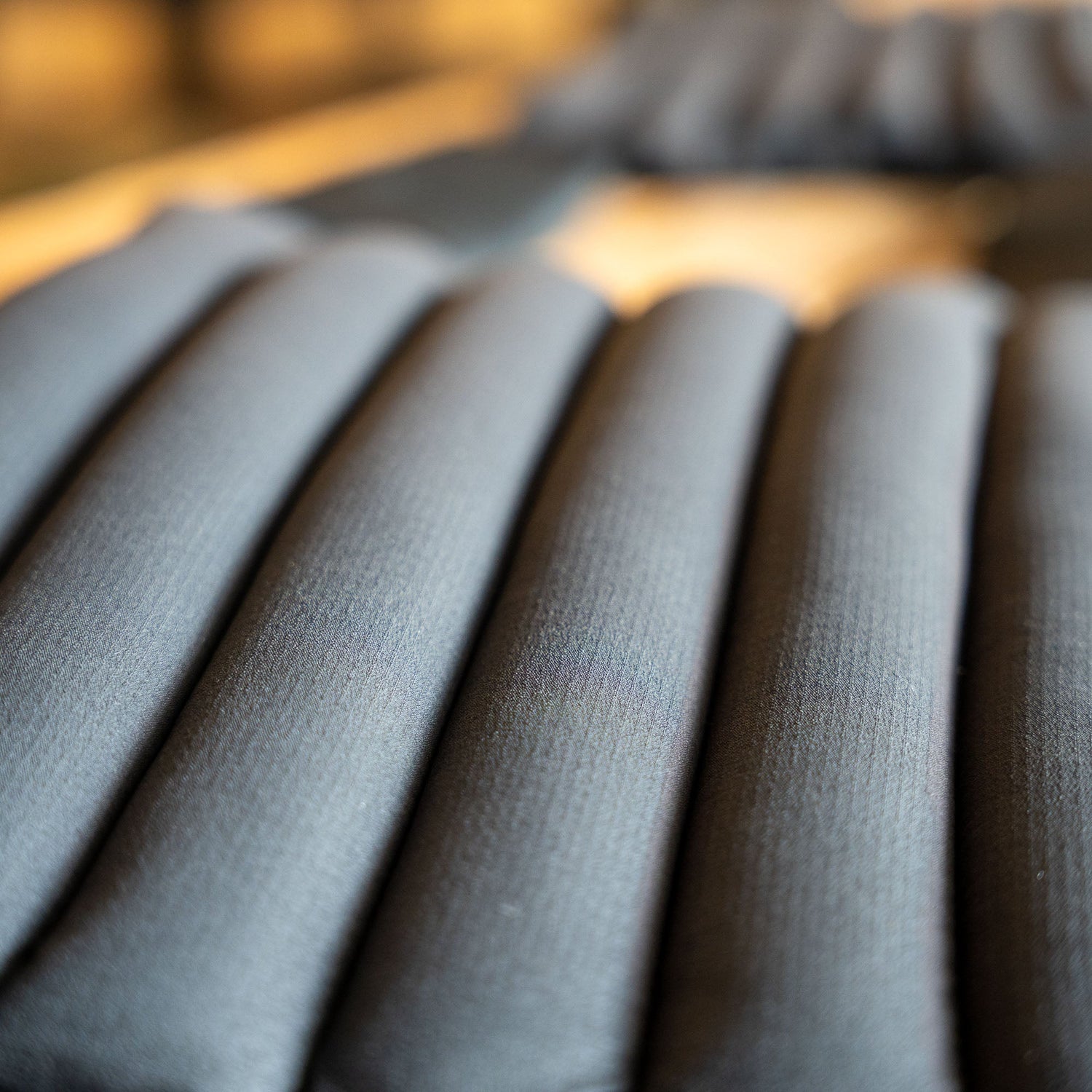 Close-up view of several black cylindrical cushions, resembling the padding in the Achilles | Men's Weighted Vest, arranged in parallel rows.