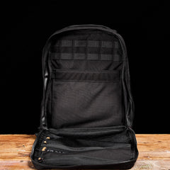 GORUCK black rucksack open on wooden table, showing interior pockets and MOLLE webbing