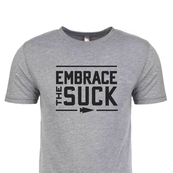 The Embrace the Suck Tee - Tri-Blend by vendor-unknown is a gray shirt featuring "Embrace The Suck," the official USMC motto, in bold black letters on the front.