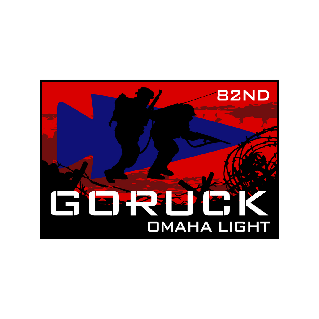 Two soldiers in silhouette with "GORUCK OMAHA LIGHT 82ND" text honor the 82nd Airborne Division against a striking red, black, and blue background, capturing the spirit of D-Day Normandy for the Normandy Event Weekend.