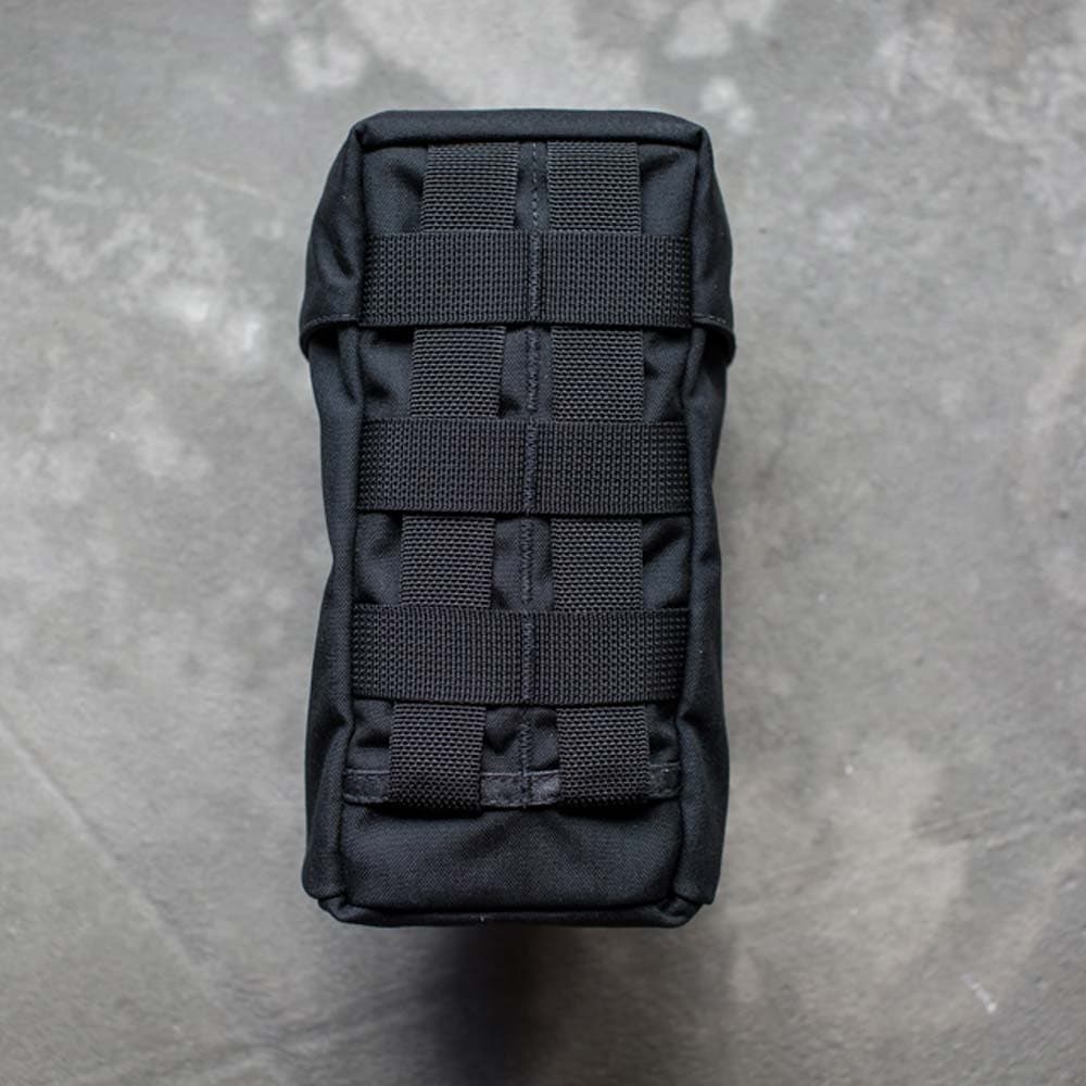 GORUCK Full Panel Water Bottle Pocket with MOLLE attachment system, viewed from above, on a gray textured surface.