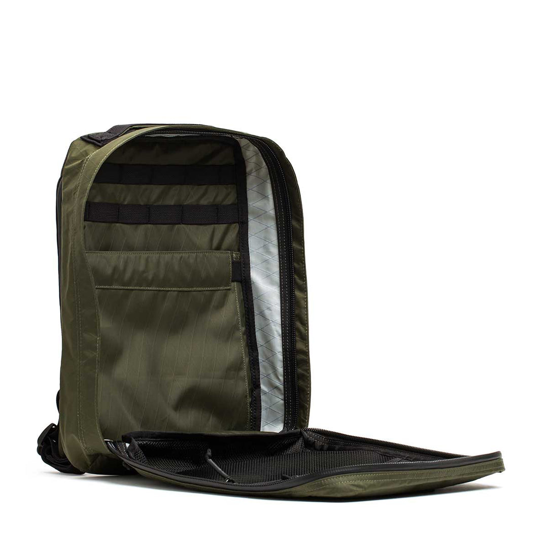 The GORUCK GR0 - X-PAC in olive green is a lightweight backpack unzipped to reveal organized interior compartments and a spacious main section.