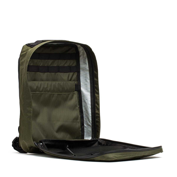 The GORUCK GR0 - X-PAC in olive green is a lightweight backpack unzipped to reveal organized interior compartments and a spacious main section.