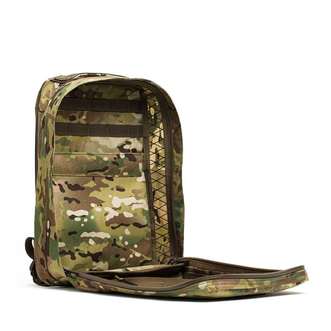 The GORUCK GR0 - X-PAC tactical backpack, made from lightweight, waterproof X-PAC material with a camouflage pattern, is unzipped and standing upright on a white background.
