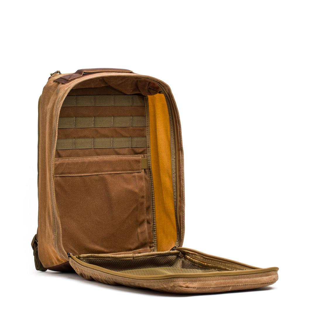 The GR1 USA - Heritage by GORUCK features a versatile open design with brown waxed duck canvas, an orange lining, and several interior compartments.